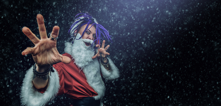 Portrait of a cool punk Santa Claus with bright dreadlocks over black background.の写真素材
