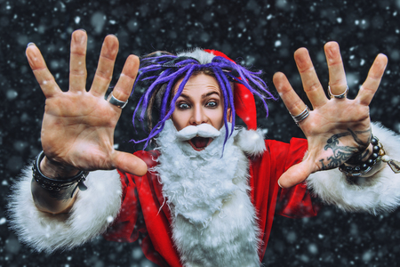 Portrait of a cool punk Santa Claus with bright dreadlocks over black background.の写真素材