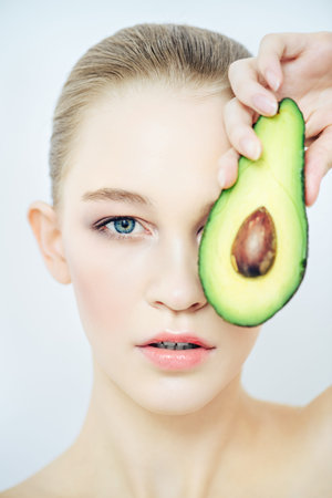 Beautiful spa woman with avocado. Beauty, natural cosmetics concept. Spa, body care.
