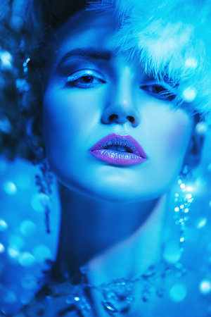 A close up portrait of a cold beautiful lady posing in the studio over the blue background. Beauty,cosmetics, hairstyle.の写真素材