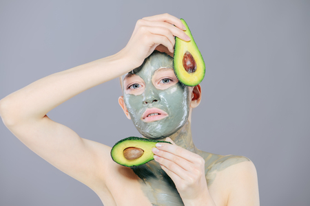 Beautiful spa woman in facial mask and avocados. Beauty, natural cosmetics concept. Spa, body care.の写真素材
