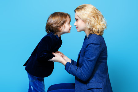 Mother and her son are posing in the studio and wearing casual clothes. Family, fashion.