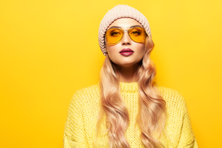 A portrait of a bright beautiful lady in yellow wearing suglasses. Casual fashion, beauty, optics.の写真素材