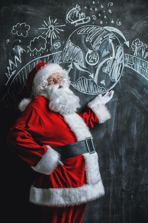 A portrait of Santa Claus standing in a classroom near the blackboard. Merry Christmas and Happy New Year!の写真素材