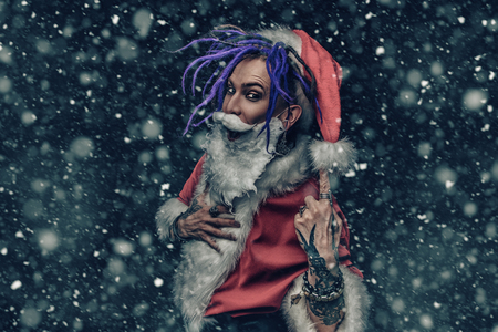 Portrait of a cool punk Santa Claus with bright dreadlocks over black background.の写真素材