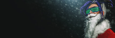 Portrait of a cool punk Santa Claus in luminous glasses with bright dreadlocks over black background.の写真素材