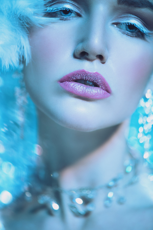 A close up portrait of a cold beautiful lady posing in the studio over the blue background. Beauty,cosmetics, hairstyle.の写真素材