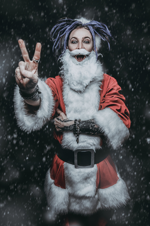 Portrait of a cool punk Santa Claus with bright dreadlocks over black background.の写真素材