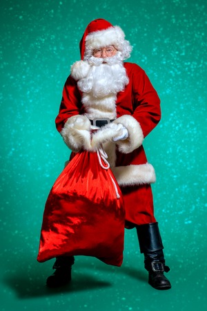 A portrait of Santa Claus with a big heavy gift bag. Merry Christmas and Happy New Year!の写真素材