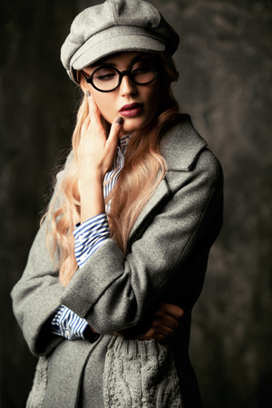 A portrait of a fashionable bright lady posing in studio over grunge background. Fashion for women.の写真素材