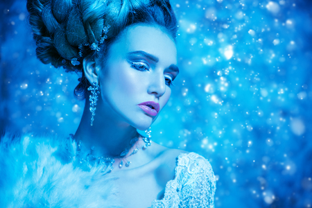 A close up portrait of a cold beautiful lady posing in the studio over the blue background. Beauty,cosmetics, hairstyle.の写真素材