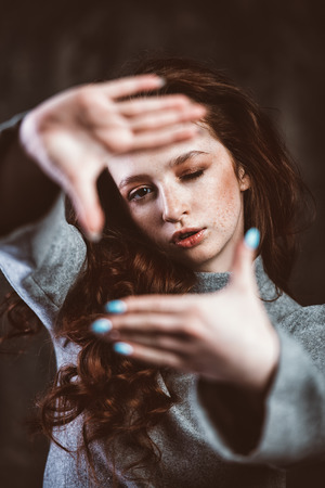 Modern  fifteen-year-old girl with long curly red hair is dancing in the studio. Beauty, fashion. Vogue dance.の写真素材