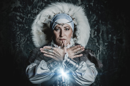 Portrait of an elderly native woman in a fur hood. A national costume. Mature lady.の写真素材