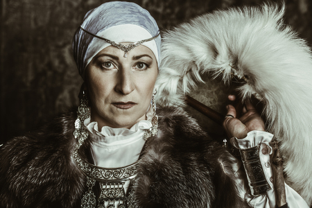 Portrait of an elderly native woman in a fur hood. A national costume. Mature lady.の写真素材