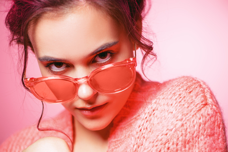 Beautiful girl with pink hair wearing bright clothes over pink background. Bright style, fashion.の写真素材