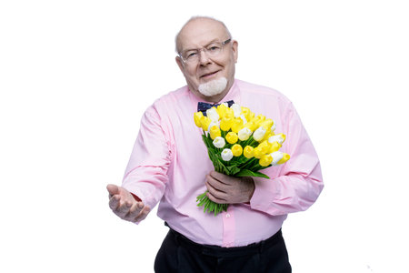 Happy smiling old man gives a bouquet of tulips flowers. Women's Day, 8 of March, birthday concept....