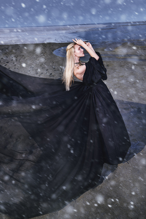 Full length portrait of a beautiful gothic woman in long black dress posing outdoor. Beauty, fashion.の写真素材