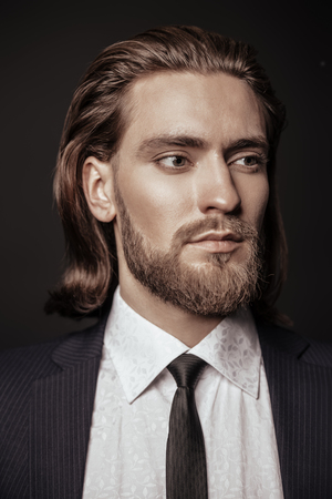 Close-up portrait of a bearded handsome young man in elegant clothes. Male beauty, fashion. Hair styling, barbershop.の写真素材