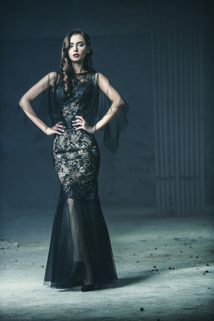 A beautiful brunette lady is in ruins. Evening dress. Fashion, beauty.の写真素材