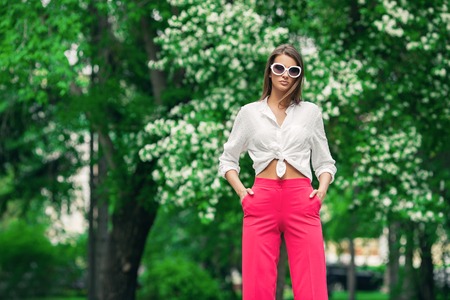 Fashion shot. Beautiful sexy woman posing in bright clothes outdoor on a summer day. Full length portrait.の写真素材