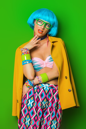 Portrait of a fashion girl with blue hair wearing bright summer clothes over green background. Beauty, fashion concept.  Pin-up style.の写真素材