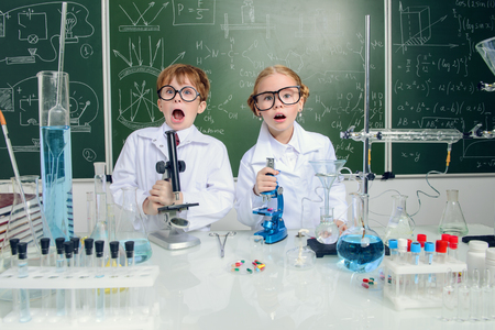 Funny girl and boy scientists are conducting an experiment in the laboratory. Educational concept. Early development of children.の写真素材