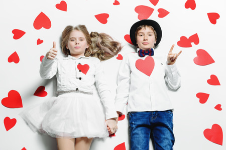 Happy pre-teen boy and girl  are posing surrounded by hearts. Friendship. First love. Valentine's Day.の写真素材