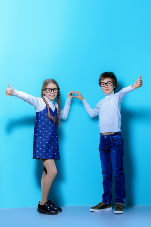 Happy spectacled children are posing on blue  background. Happy childhood. Spring holidays.の写真素材