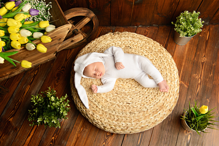Cute newborn baby lies on a wooden background, dressed in rabbit costume. Easter holiday. Scenery in the rustic style.の写真素材