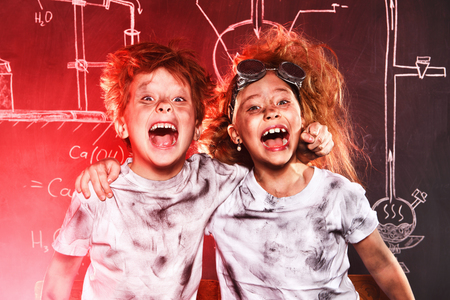 Funny school children doing experiments in the laboratory. Explosion in the laboratory. Science and education.の写真素材