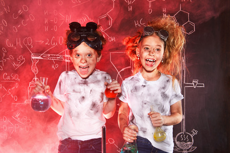 Funny school children doing experiments in the laboratory. Explosion in the laboratory. Science and education.の写真素材