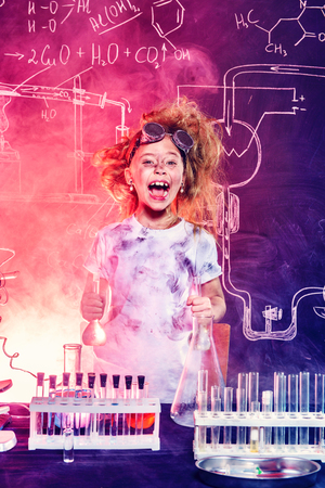 Funny little girl doing experiments in the laboratory. Explosion in the laboratory. Science and education.の写真素材