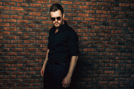 Handsome bearded man wearing black shirt and sunglasses. Male fashion.の写真素材