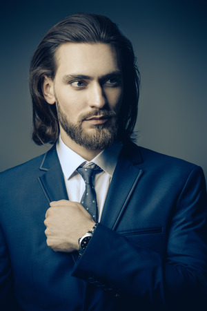 Fashion shot. Handsome young man posing in elegant blue suit and white shirt. Men's beauty, fashion.の写真素材
