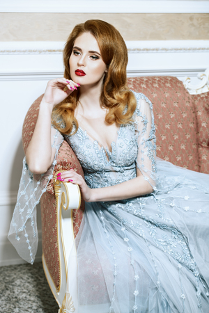 A portrait of a beautiful elegant woman in the wedding dress on the couch. Fashion, wedding dress.の写真素材