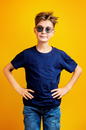 Portrait of a boy in casual clothes on a yellow background in the Studio. Childhood, kids. Casual style.の写真素材