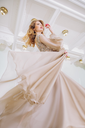 A portrait of a beautiful elegant woman in the fluttering wedding dress. Fashion, wedding dress.の写真素材