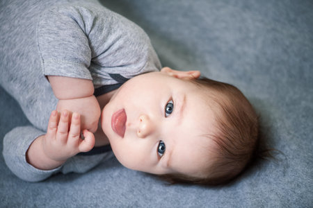 A portrait of a beautiful baby lying in the bed. Family, parenthood. Goods for newborns.の写真素材