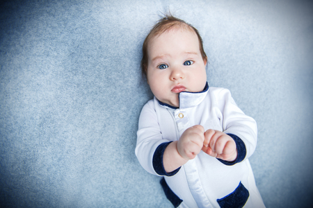 A portrait of a beautiful baby lying in the bed. Family, parenthood. Goods for newborns.の写真素材