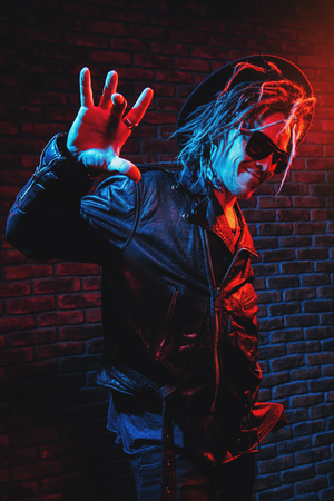 Portrait of a crazy disco man with dreadlocks. Party, disco. Colorful light.の写真素材