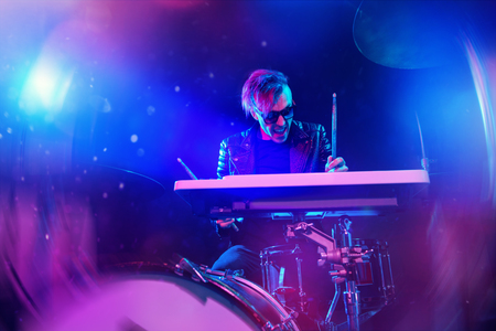 A crazy man is playing the drums in a dark room. Party, disco. Musical instrument.の写真素材