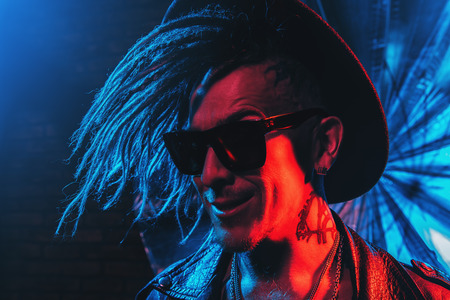 Portrait of a crazy disco man with dreadlocks. Party, disco. Colorful light.の写真素材