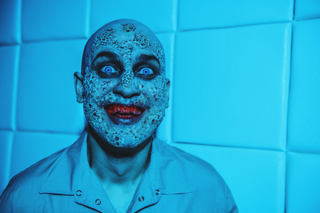 A portrait of a sick scientist after a failed experiment in the blue light. Desperation, hopelessness. Horror, halloween.の写真素材
