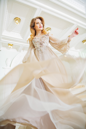 A portrait of a beautiful elegant woman in the fluttering wedding dress. Fashion, wedding dress.の写真素材