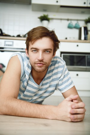 A close up portrait of a handsome dreamy man. Home, casual fashion.の写真素材