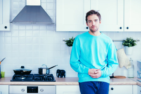 A portrait of a handsome man in a light blue sweater. Beauty, fashion for men.