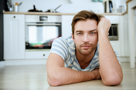A close up portrait of a handsome dreamy man. Home, casual fashion.の写真素材