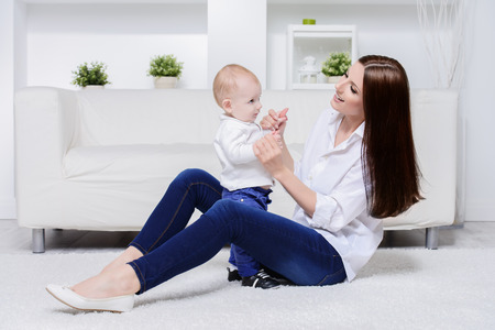Happy young mother playing with her small baby. Family concept. Healthcare, pediatrics.の写真素材