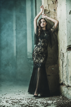 A beautiful brunette lady in ruins. Evening dress. Fashion, beauty.の写真素材