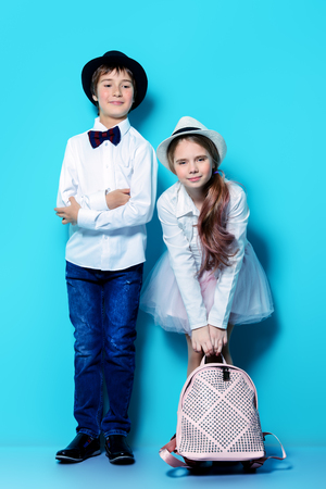 Happy children are posing in elegant clothes on blue  background. Happy childhood. Spring holidays.の写真素材